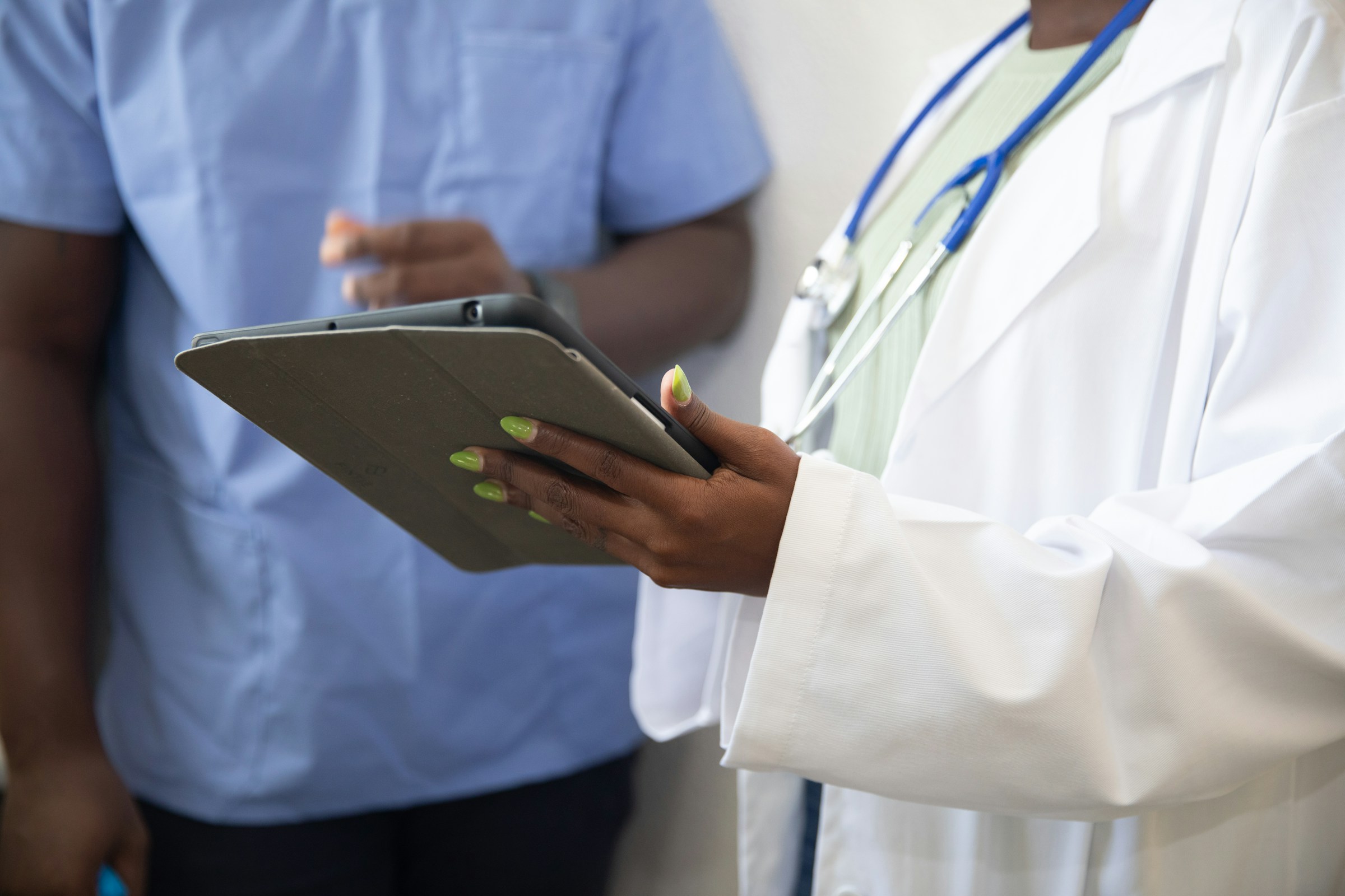 A doctor showing a tablet to another. Photo by Nappy on Unsplash